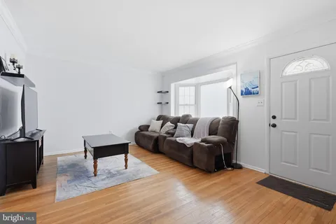 a living room with furniture a flat screen tv and a wooden floor