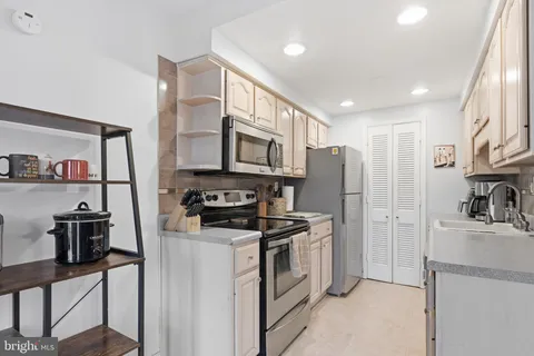 a kitchen with stainless steel appliances granite countertop a refrigerator stove microwave and sink