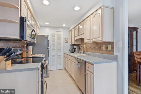 a kitchen with a sink a stove and cabinets