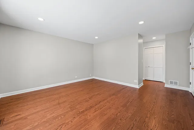 a view of an empty room with wooden floor