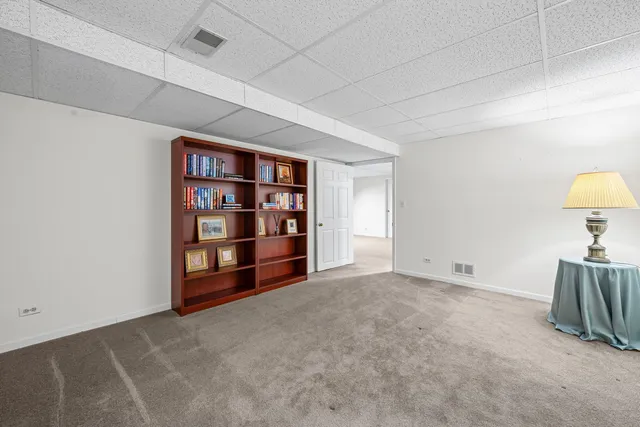 a view of an empty room with a cabinet and bookshelf