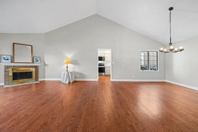 a view of empty room with wooden floor fireplace and windows