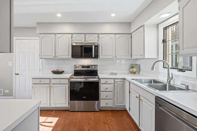 a kitchen with stainless steel appliances a stove sink microwave and cabinets