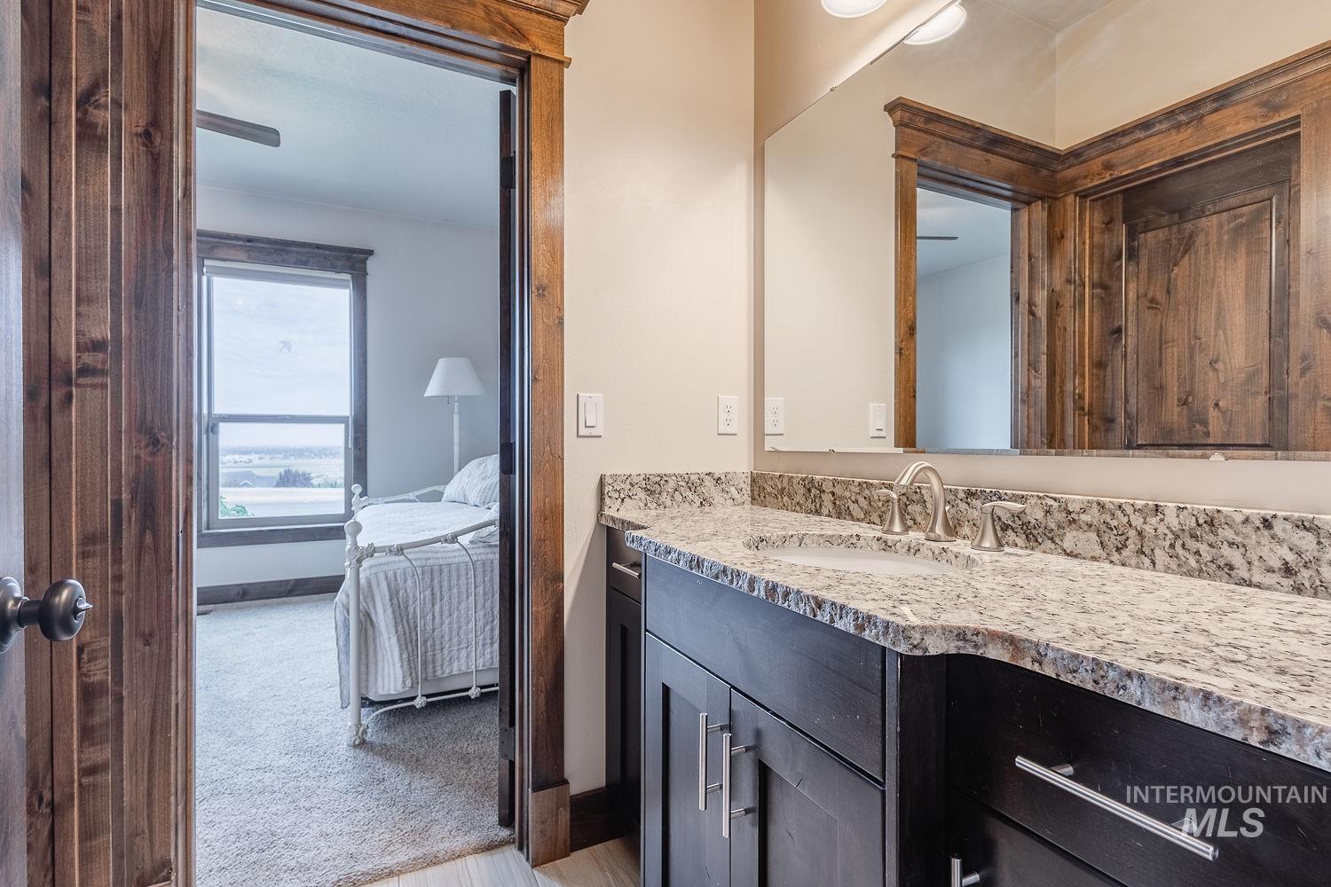 8077 Star Pass Ridge Road Nampa, ID 83686 - Photo 28 of 37 Bathroom vanity featuring a speckled countertop, undermount sink, and brushed nickel faucet
