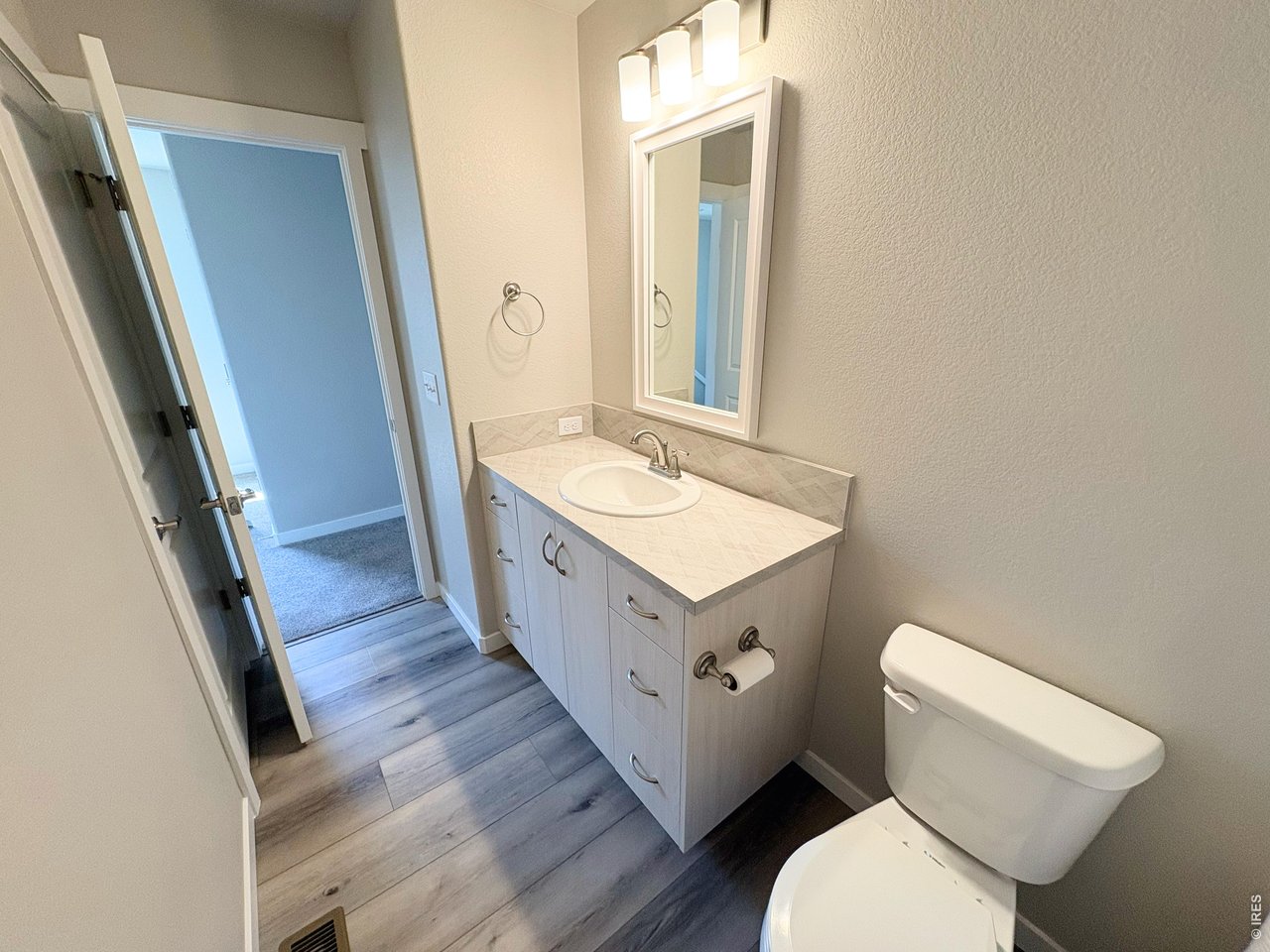 333 Pyramid Peak Street Berthoud, CO 80513 - Photo 15 of 21 a bathroom with a sink a toilet a mirror and vanity
