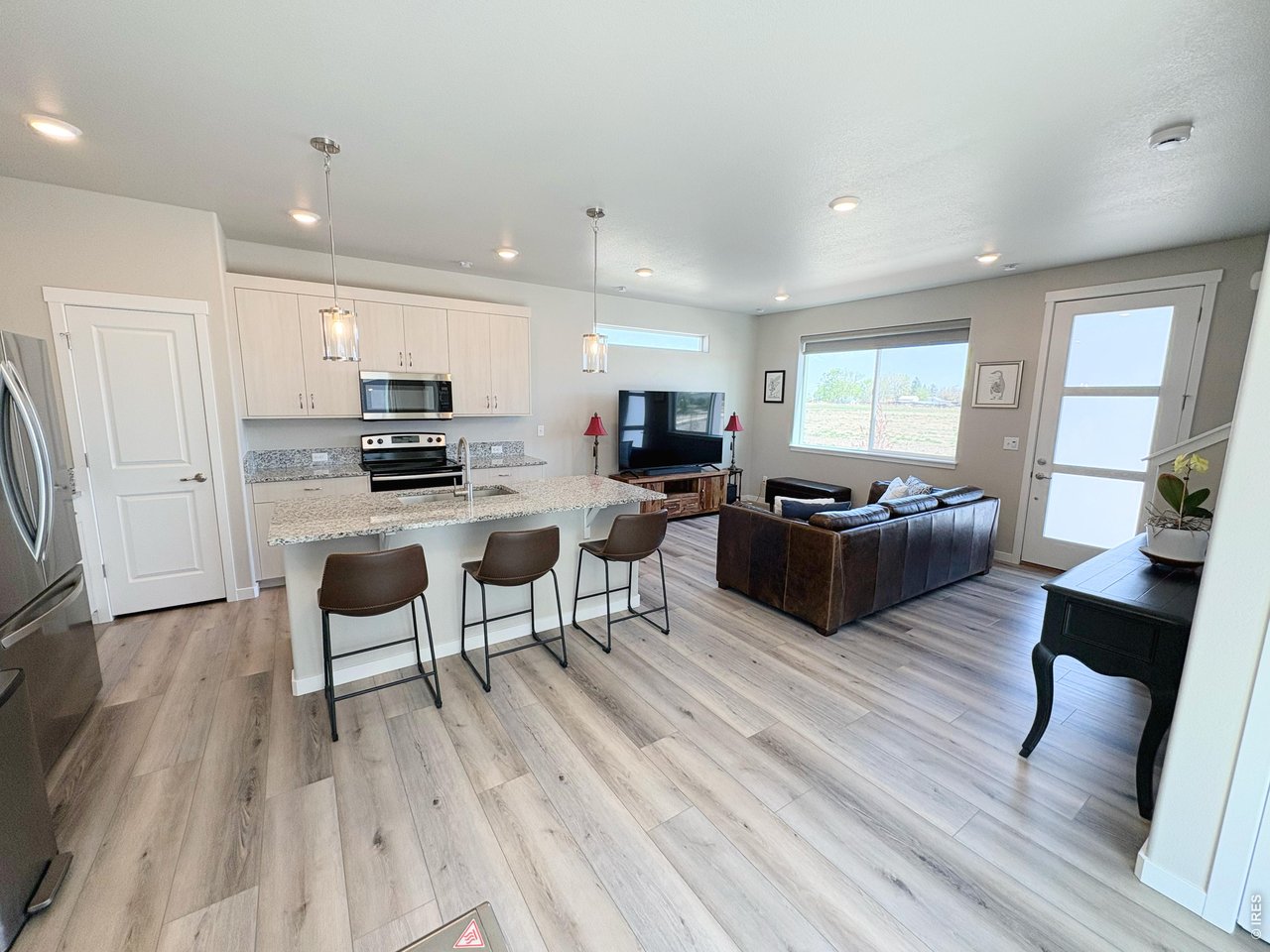 333 Pyramid Peak Street Berthoud, CO 80513 - Photo 5 of 21 a living room with stainless steel appliances furniture and a wooden floor