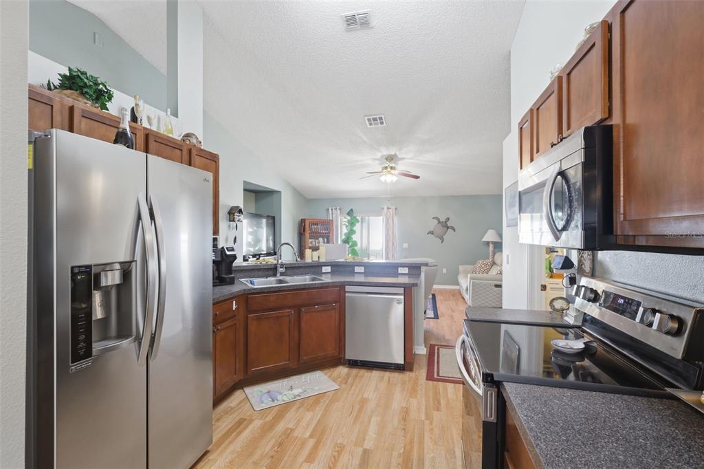403 Central Mariners Drive Edgewater, FL 32141 - Photo 14 of 42 a kitchen with stainless steel appliances granite countertop a refrigerator a stove a sink a dining table and chairs