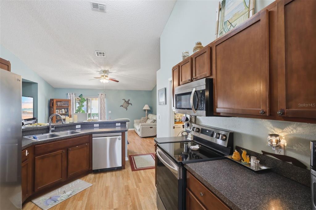 403 Central Mariners Drive Edgewater, FL 32141 - Photo 17 of 42 a kitchen with stainless steel appliances granite countertop a sink stove and refrigerator