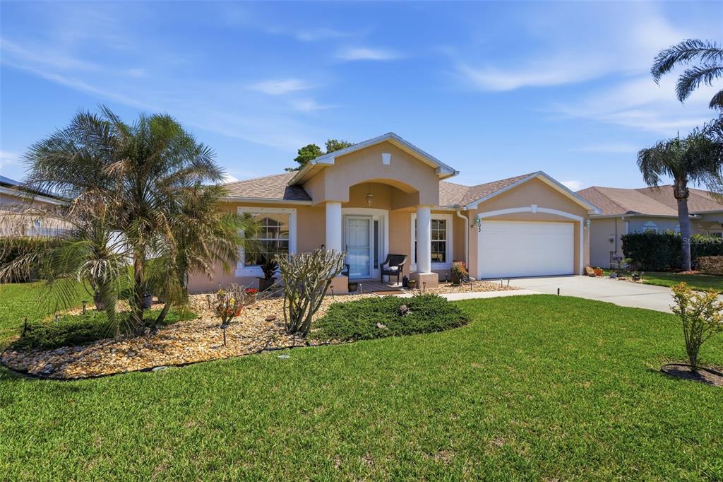 403 Central Mariners Drive Edgewater, FL 32141 - Photo 3 of 42 a front view of a house with a garden and yard