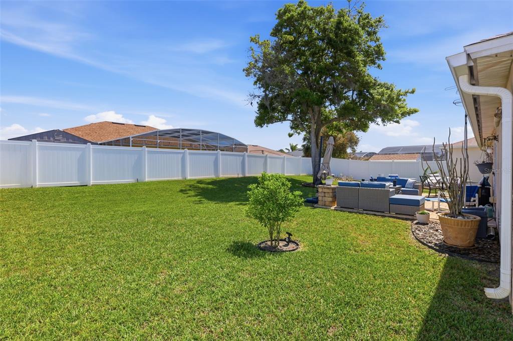 403 Central Mariners Drive Edgewater, FL 32141 - Photo 35 of 42 a view of a backyard with table and chairs potted plants and a large tree