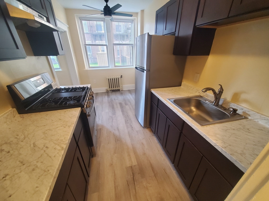a kitchen with a sink a refrigerator and window