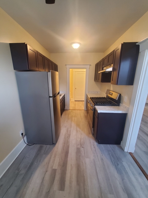 415 County Street, Unit 116 New Bedford, MA 02740 - Photo 3 of 14 a view of kitchen with refrigerator stove and wooden floor