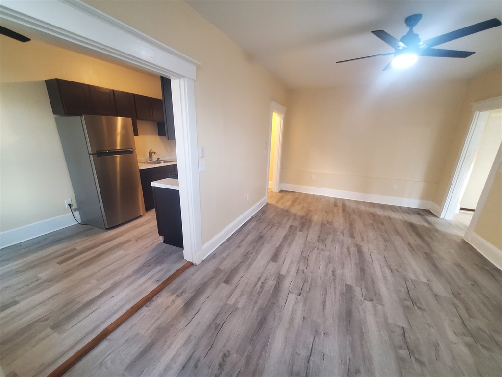 415 County Street, Unit 116 New Bedford, MA 02740 - Photo 4 of 14 wooden floor in an empty room with a window