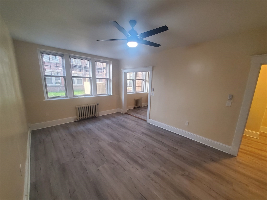 415 County Street, Unit 116 New Bedford, MA 02740 - Photo 5 of 14 an empty room with wooden floor and windows