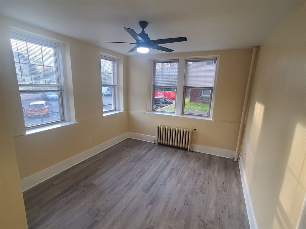 415 County Street, Unit 116 New Bedford, MA 02740 - Photo 6 of 14 a view of an empty room with wooden floor and a window