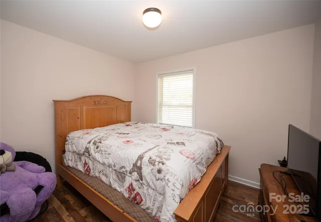 a bedroom with a bed and a computer on a dresser