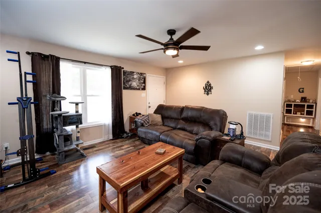 a living room with furniture a ceiling fan and a window