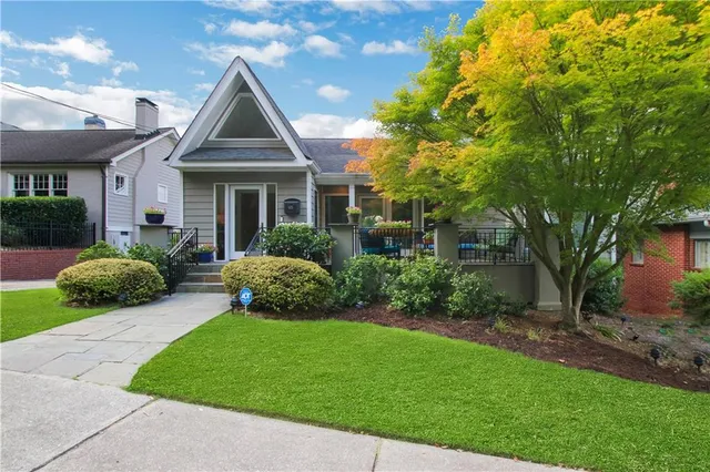 a front view of a house with a garden and plants