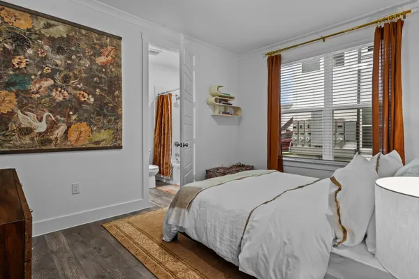a bedroom with a bed and a painting on the wall