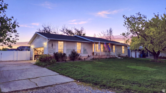 View of front of home with a gate, a porch, concrete driveway, and an attached garage