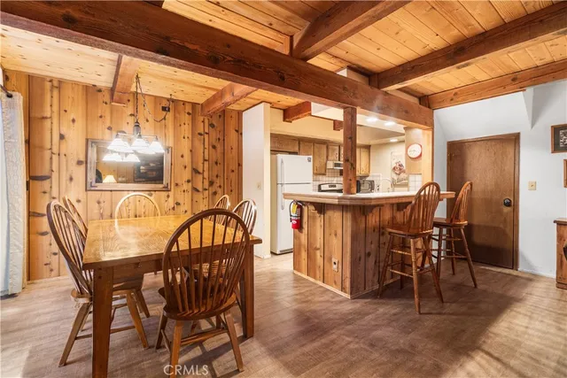 a dining room with furniture a chandelier and wooden floor