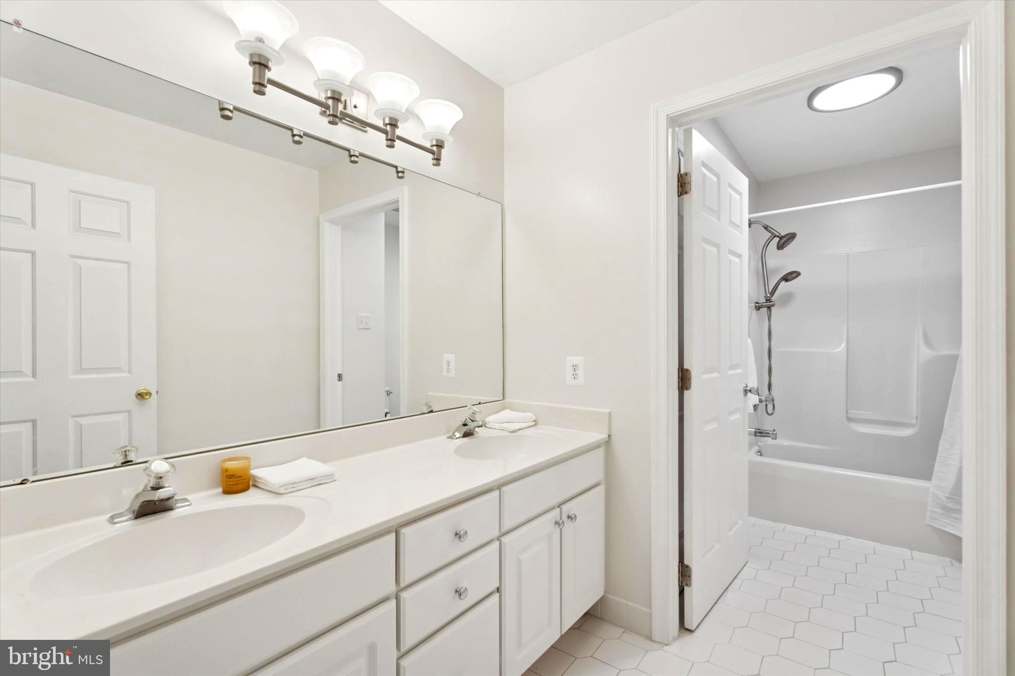 164 West Thompson Avenue Springfield, PA 19064 - Photo 20 of 28 a bathroom with a double vanity sink a mirror and a bathtub