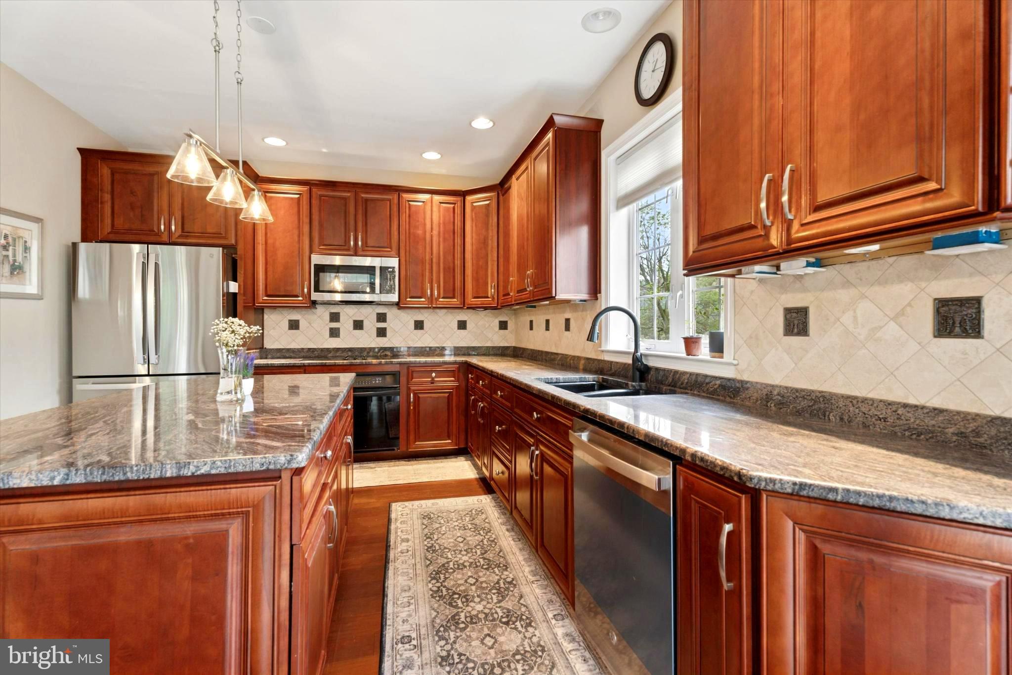 164 West Thompson Avenue Springfield, PA 19064 - Photo 8 of 28 a kitchen with stainless steel appliances granite countertop a sink stove microwave and refrigerator