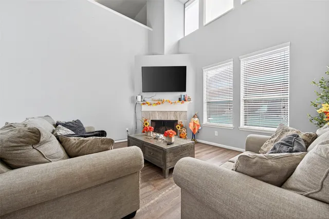 a living room with furniture a flat screen tv and a fireplace