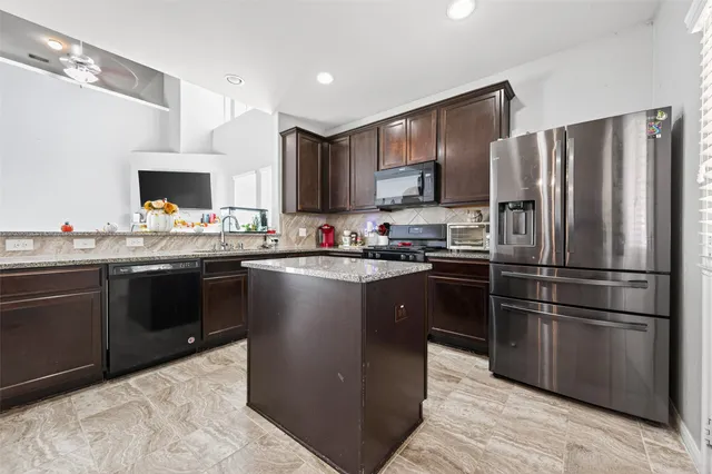 a kitchen with kitchen island a sink cabinets and stainless steel appliances