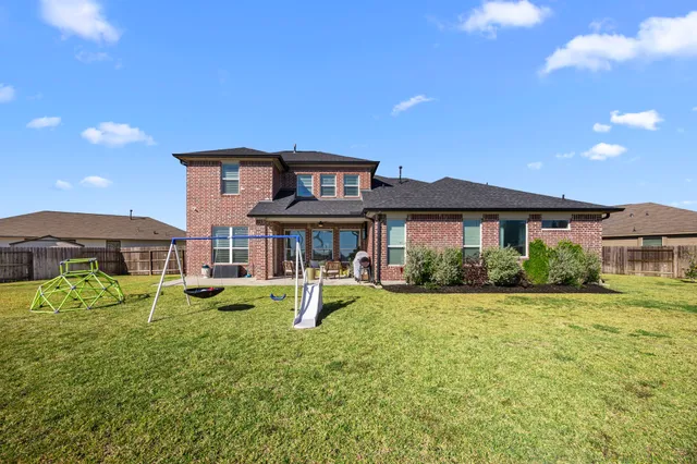 a view of a house with a big yard and large trees