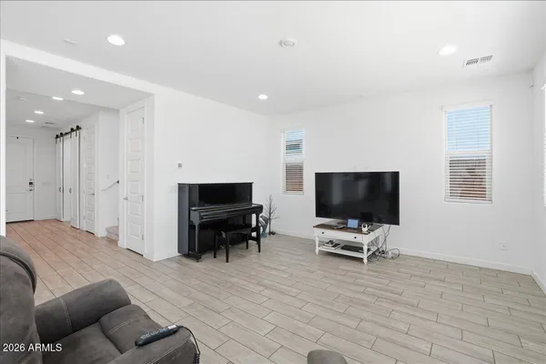 a living room with furniture a wooden floor and a piano