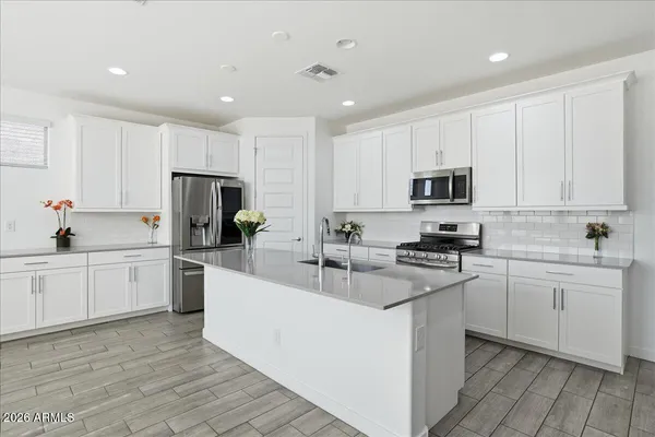 a kitchen with counter top space a sink a stove and cabinets