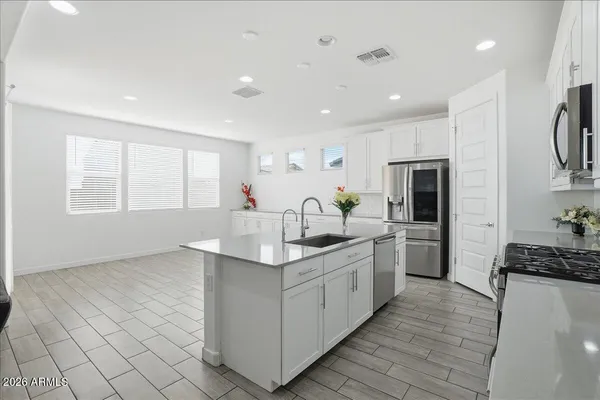 a kitchen with stainless steel appliances granite countertop a sink a stove and a refrigerator