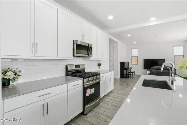 a view of an empty room with window and cabinet area