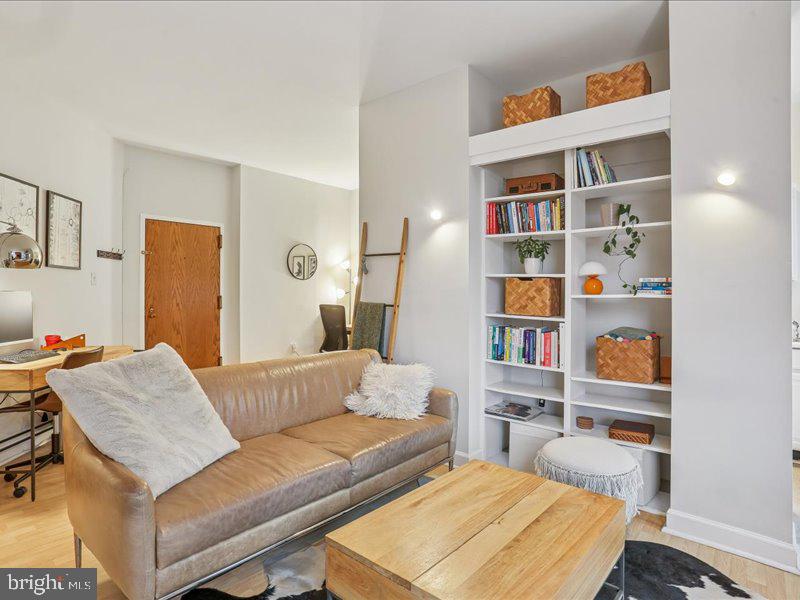 1615 Q Street Northwest, Unit 201 Washington, DC 20009 - Photo 11 of 20 a living room with furniture and a book shelf