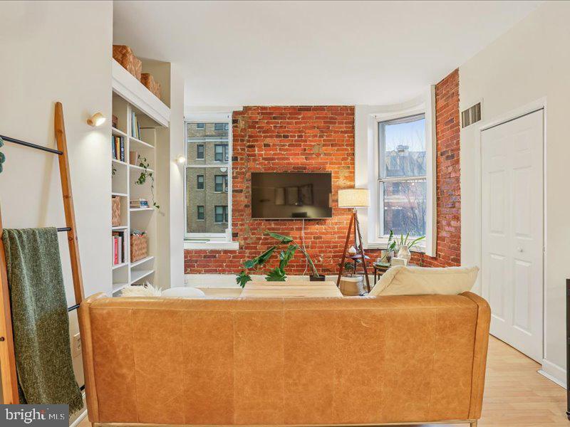 1615 Q Street Northwest, Unit 201 Washington, DC 20009 - Photo 8 of 20 a view of a living room with furniture and a flat screen tv