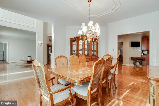a dining room with furniture a chandelier and wooden floor