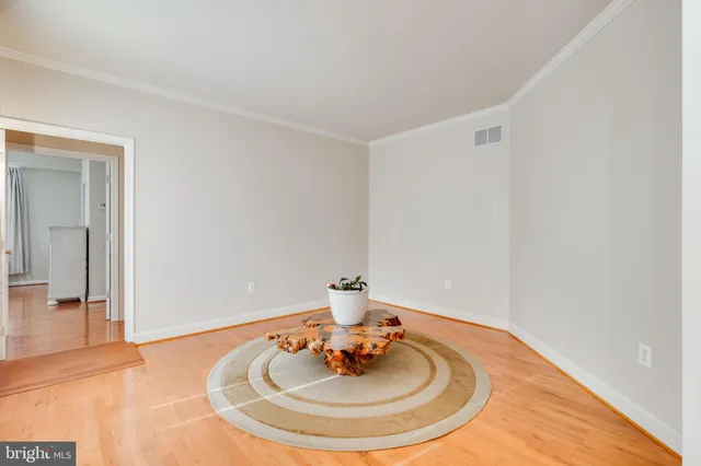 a view of a livingroom with a chandelier fan and wooden floor
