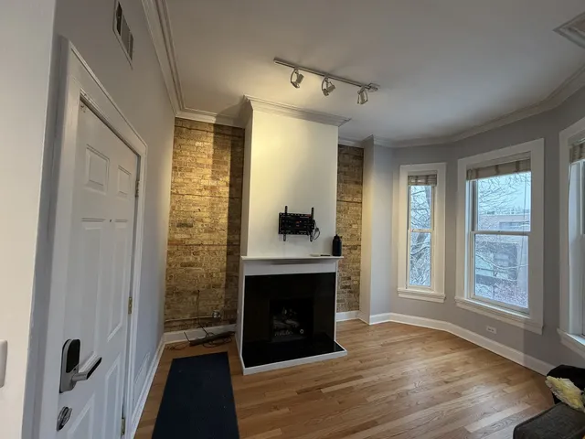 a view of a livingroom with a fireplace and window