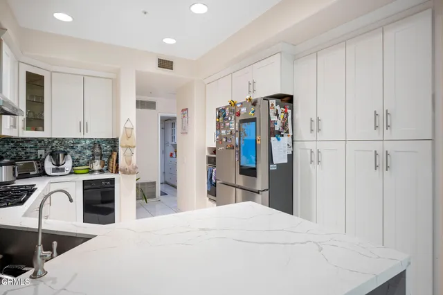 a kitchen with white cabinets and window