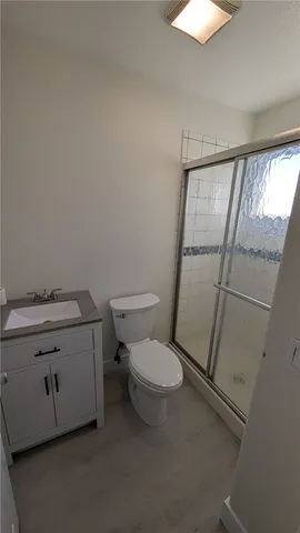 a bathroom with a granite countertop toilet and a sink