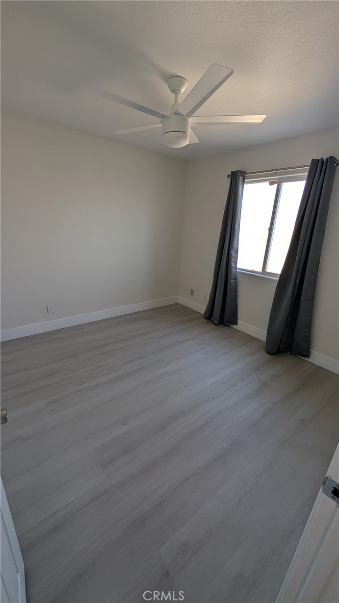 905 West Sumner Avenue, Unit B Lake Elsinore, CA 92530 - Photo 9 of 15 an empty room with wooden floor and windows