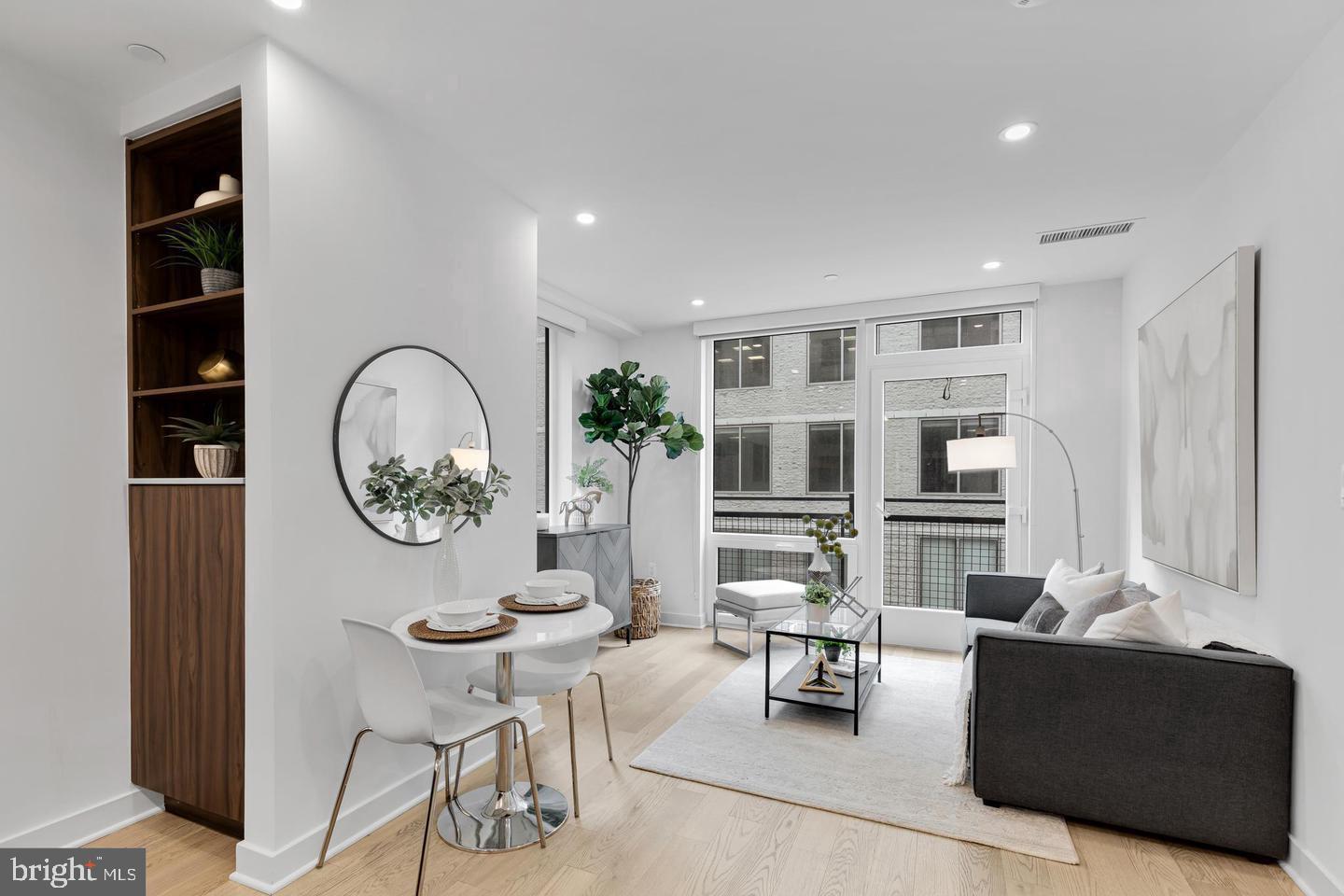 a living room with furniture a window and wooden floor