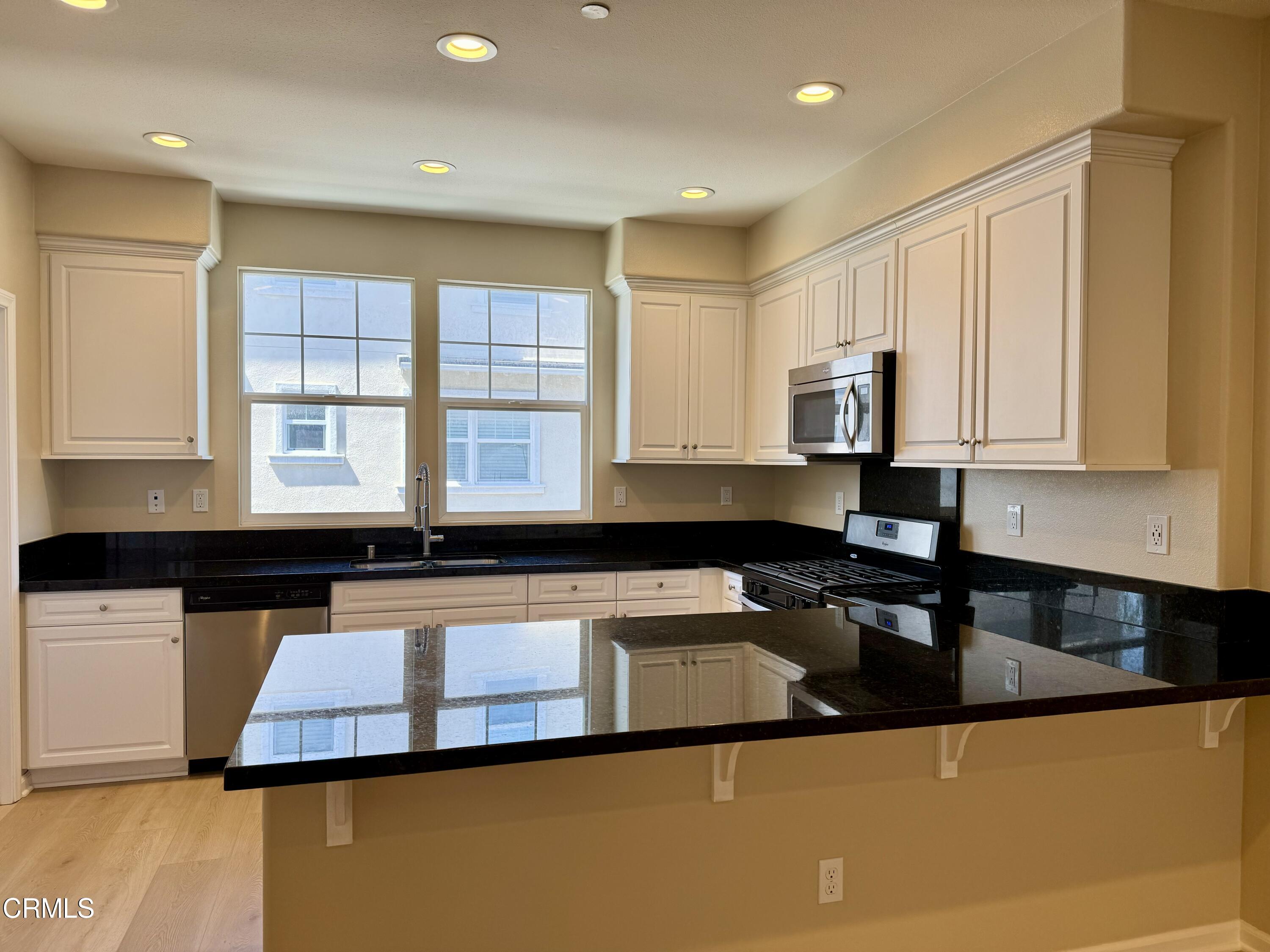 3667 Islander Walk Oxnard, CA 93035 - Photo 11 of 33 a kitchen with granite countertop a sink a stove and cabinets