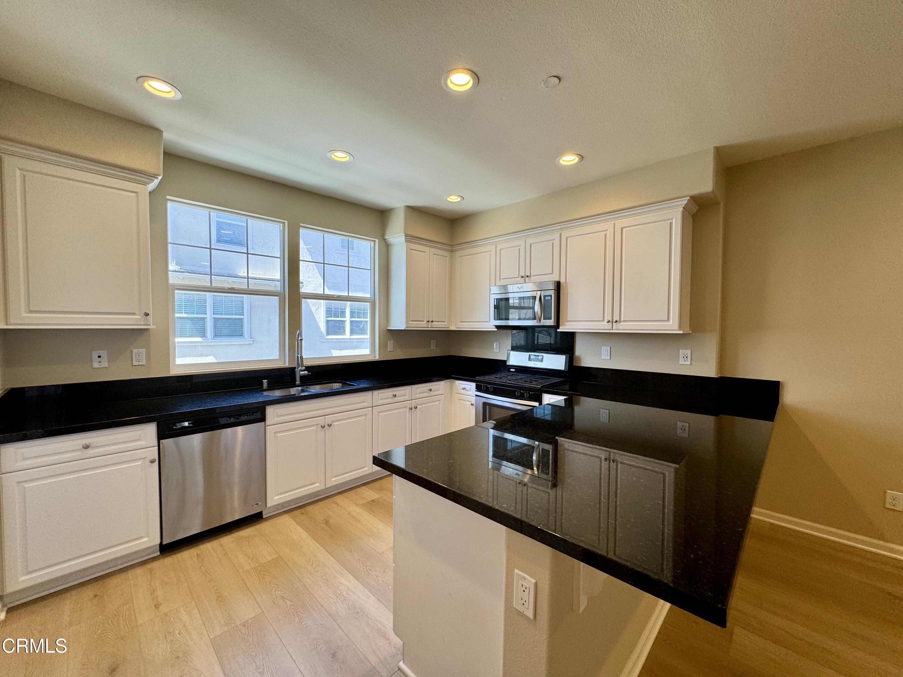 3667 Islander Walk Oxnard, CA 93035 - Photo 12 of 33 a kitchen with granite countertop a sink a counter top space and cabinets