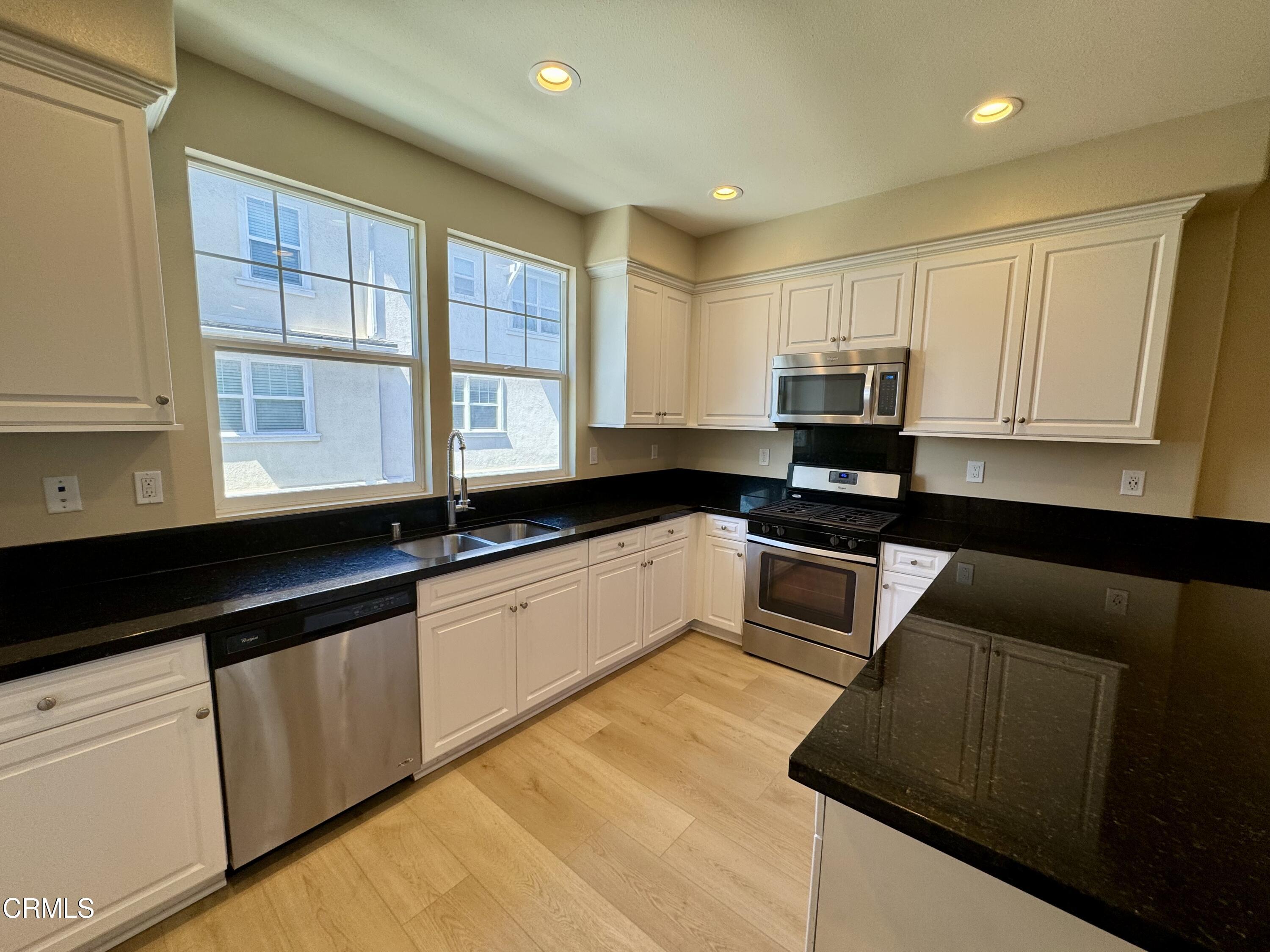 3667 Islander Walk Oxnard, CA 93035 - Photo 13 of 33 a kitchen with granite countertop white cabinets and sink