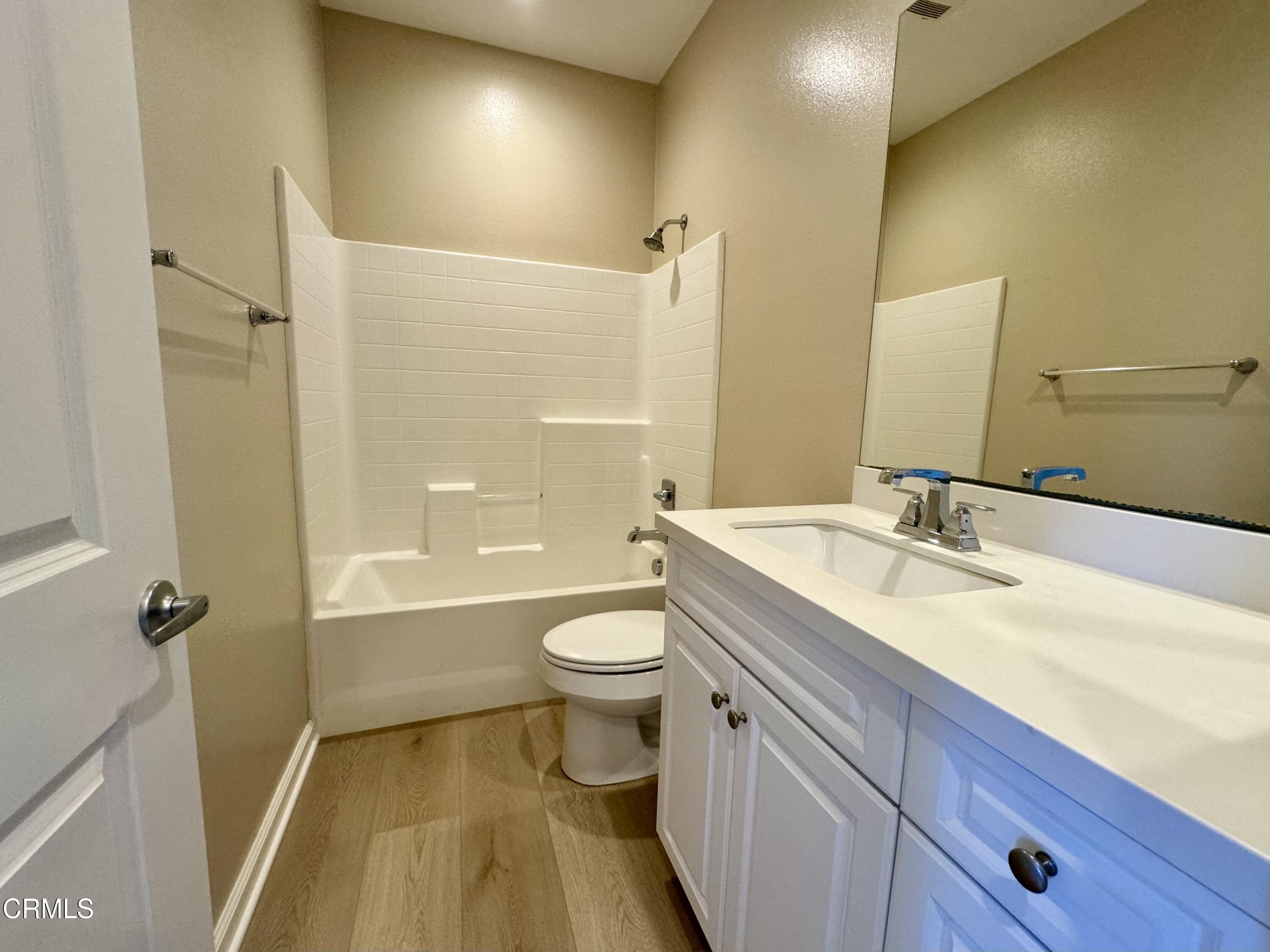 3667 Islander Walk Oxnard, CA 93035 - Photo 26 of 33 a bathroom with a granite countertop sink toilet a shower and a mirror