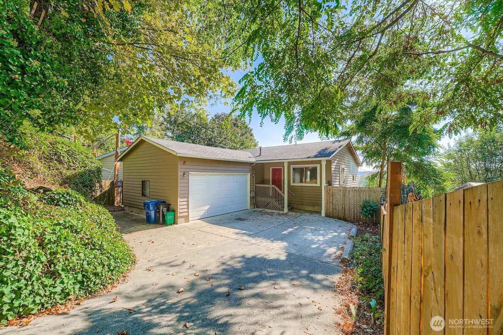 a view of a house with a yard and large tree