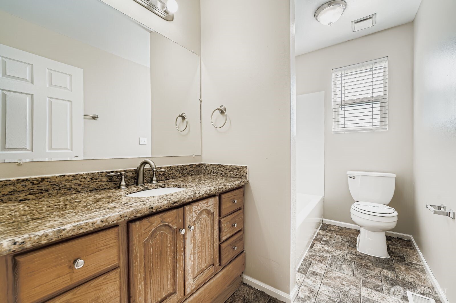 3727 South Pilgrim Street Seattle, WA 98118 - Photo 12 of 21 a bathroom with a granite countertop sink a toilet and a mirror