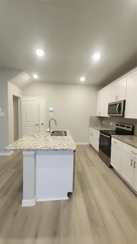 a kitchen with a sink and a stove top oven